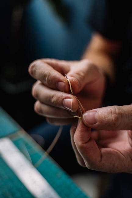 Hands working with soft, textured fabric on a wooden table